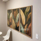 Tríptico Selva Feuillage com moldura caixinha e impressão premium. Folhas tropicais sofisticadas em tons dourados e verdes para salas e quartos elegantes.