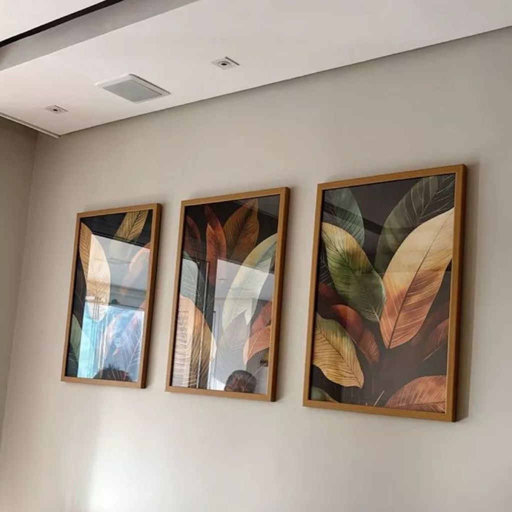 Tríptico Selva Feuillage com moldura caixinha e impressão premium. Folhas tropicais sofisticadas em tons dourados e verdes para salas e quartos elegantes.