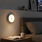 Luminária LED circular sem fio com sensor de presença e bateria recarregável. Acende só no escuro, desliga em 20s e instala fácil com base magnética e adesivo.