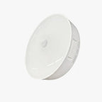 Luminária LED circular sem fio com sensor de presença e bateria recarregável. Acende só no escuro, desliga em 20s e instala fácil com base magnética e adesivo.